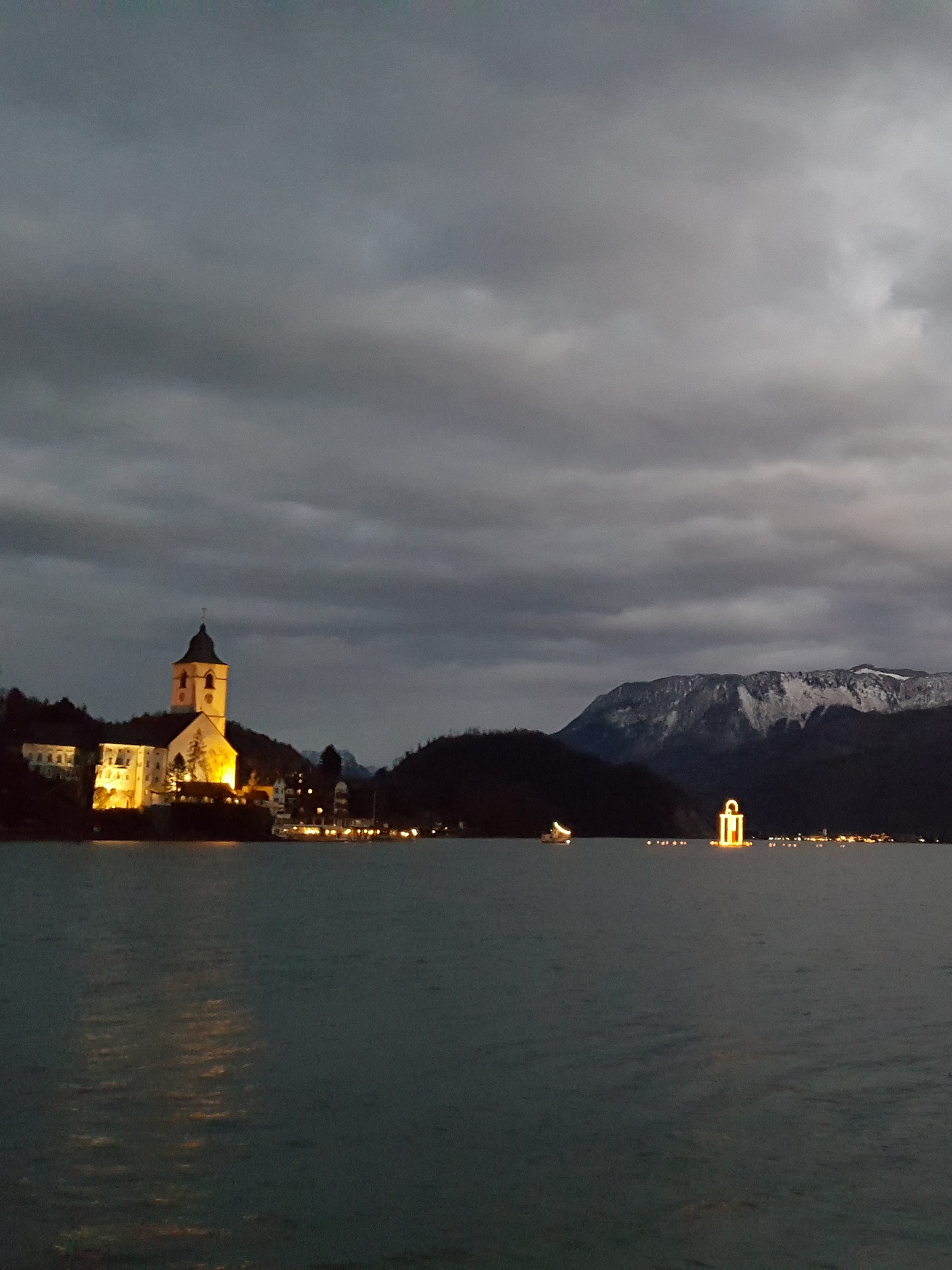 Wolfgangsee am Abend mit beleuchteter Kirche und Laterne beim Yoga Retreat im Dezember