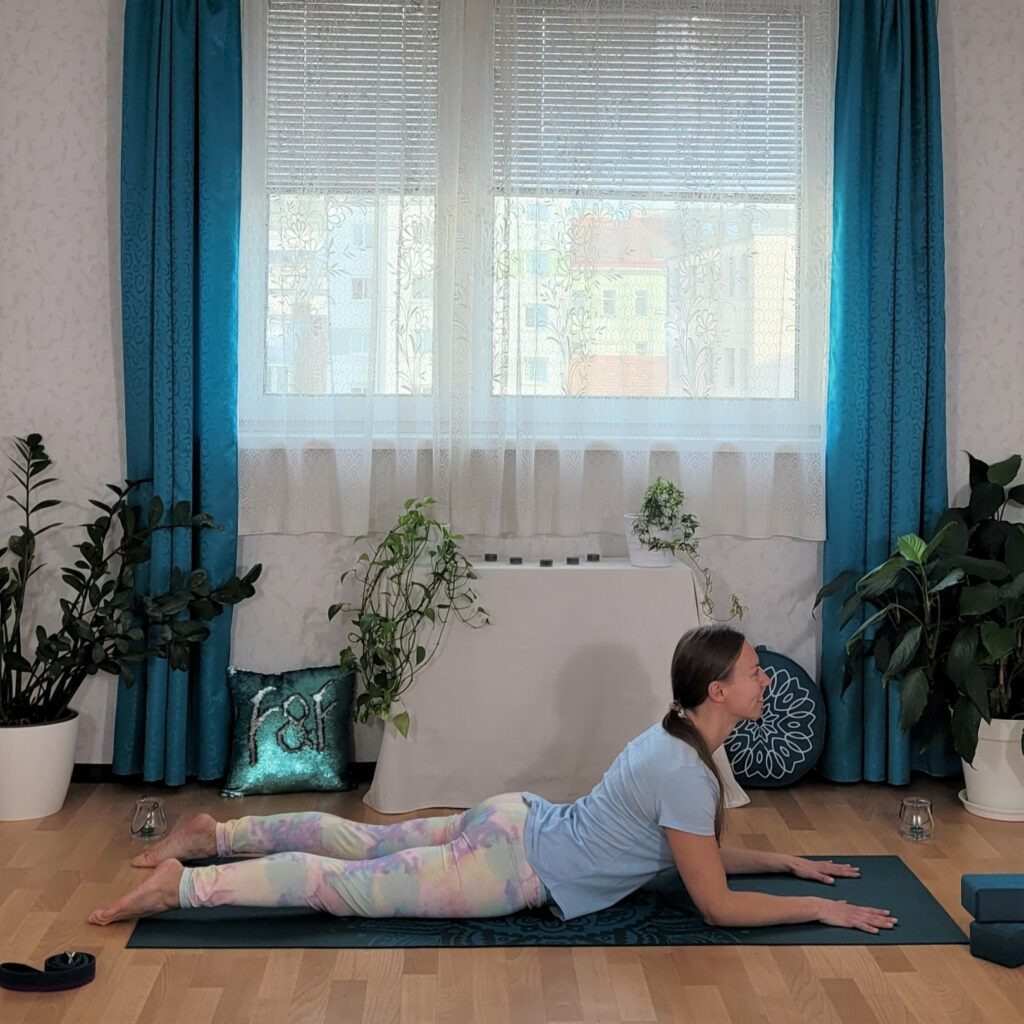 Frau in Bauchlage auf Yogamatte, die Unterarme aufgestützt