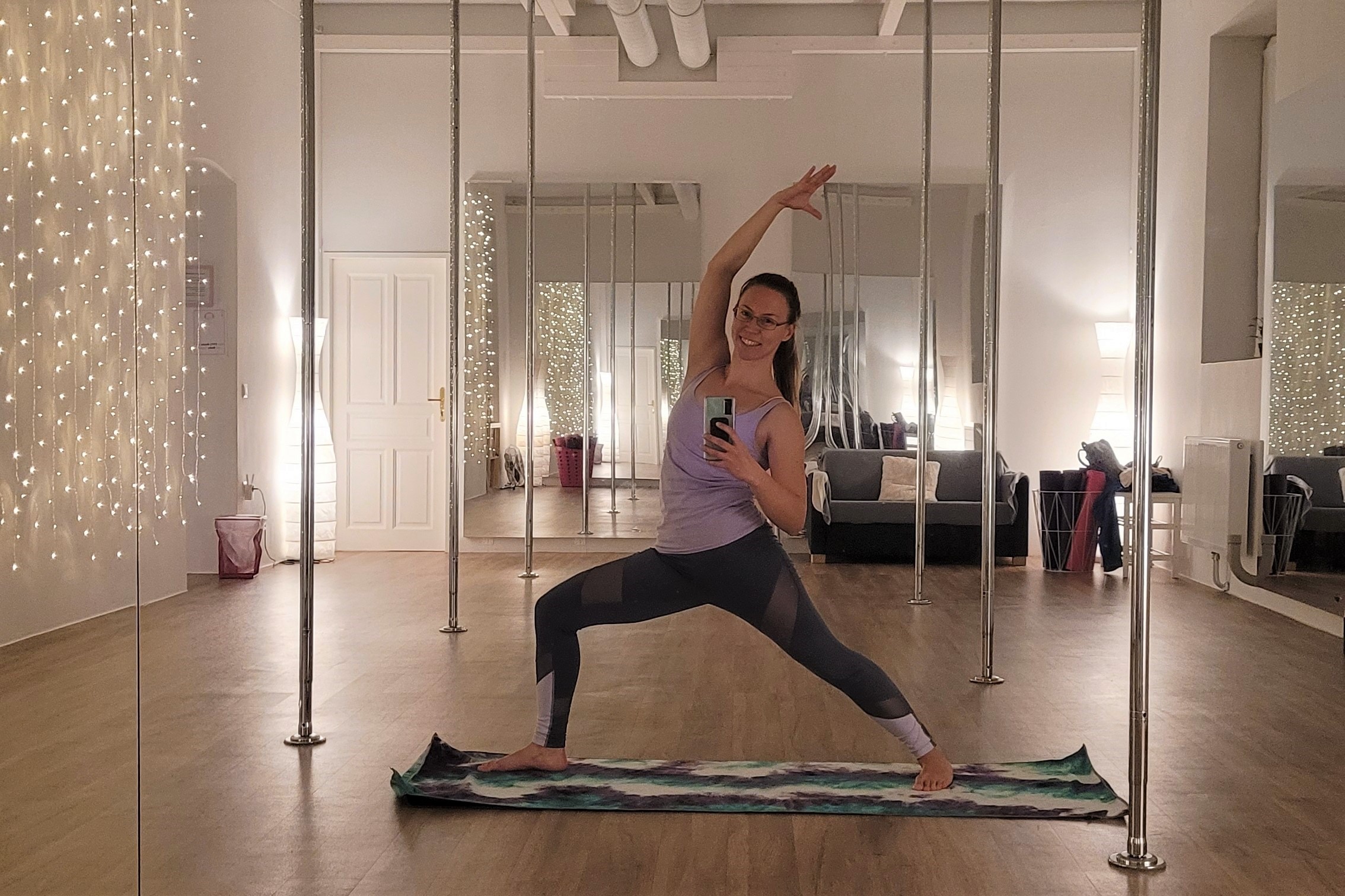 Frau übt Yoga Pose Reverse Warrior in Pole Dance Studio