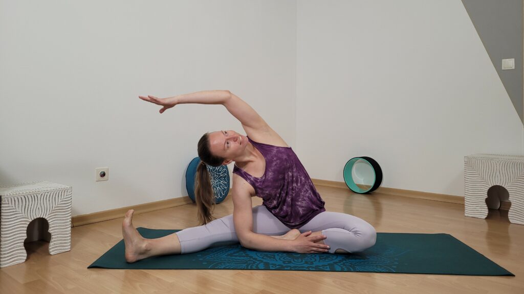 Yogalehrerin zeigt die sitzende Seitbeuge