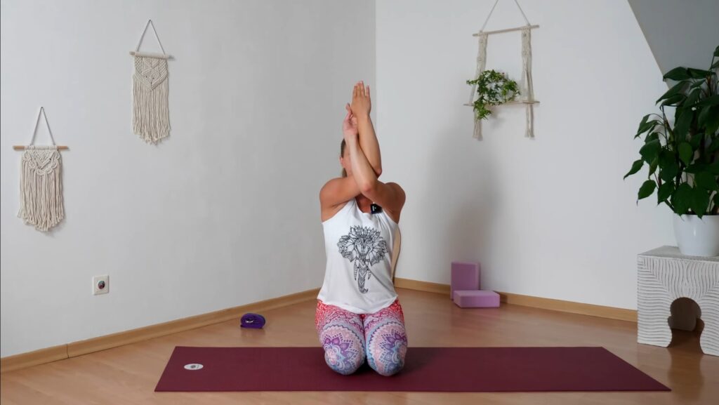 Yogalehrerin im Knien mit Adlerarmen