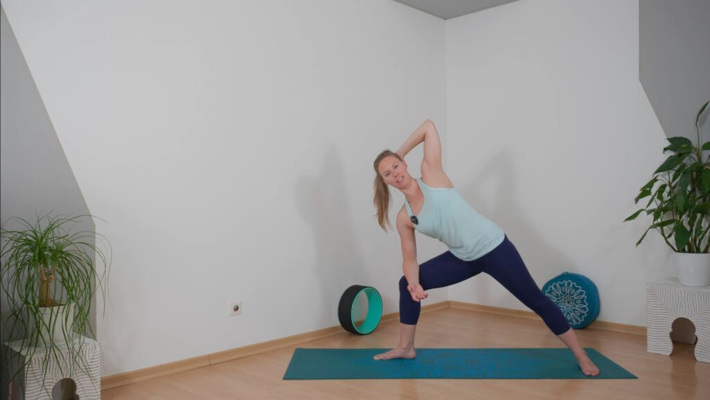 Yogalehrerin zeigt den Nacken kräftigende Variante des seitlichen Winkels