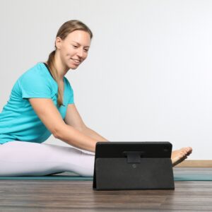 Yogalehrerin in der Langsitz Vorbeuge beim Onlinekurs für Anfänger