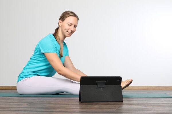 Yogalehrerin in der Langsitz Vorbeuge beim Onlinekurs für Anfänger