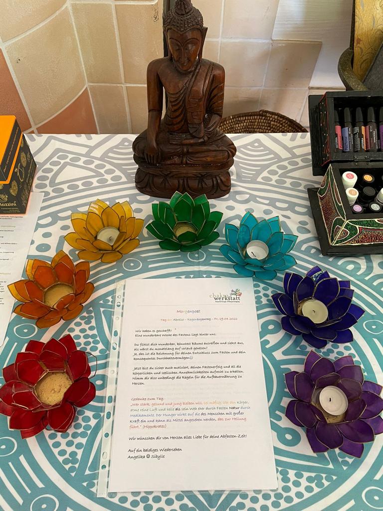 Bunte Teelichthalter und Buddhastatue dekorieren die Morgenpost beim Fasten Yoga Retreat