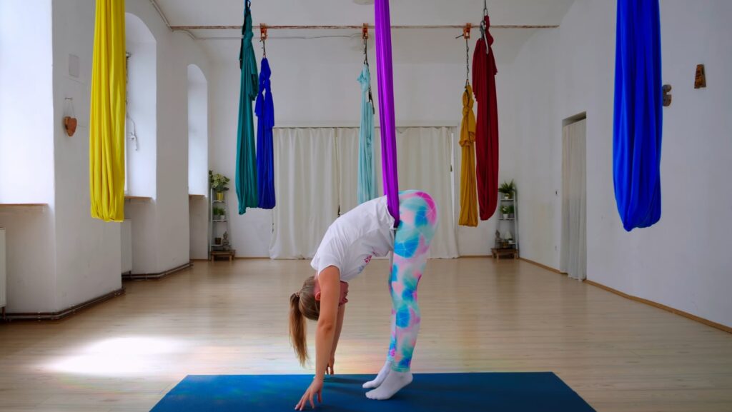 Yogalehrerin Sabrina Farkas in einer Vorbeuge mit dem Aerial Yoga Tuch im Hüftbeuger