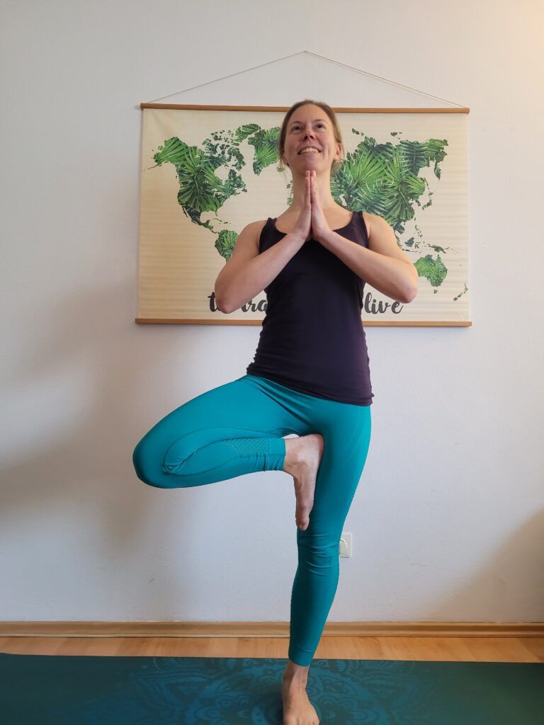 Yogalehrerin in einbeiniger Standhaltung zu Hause