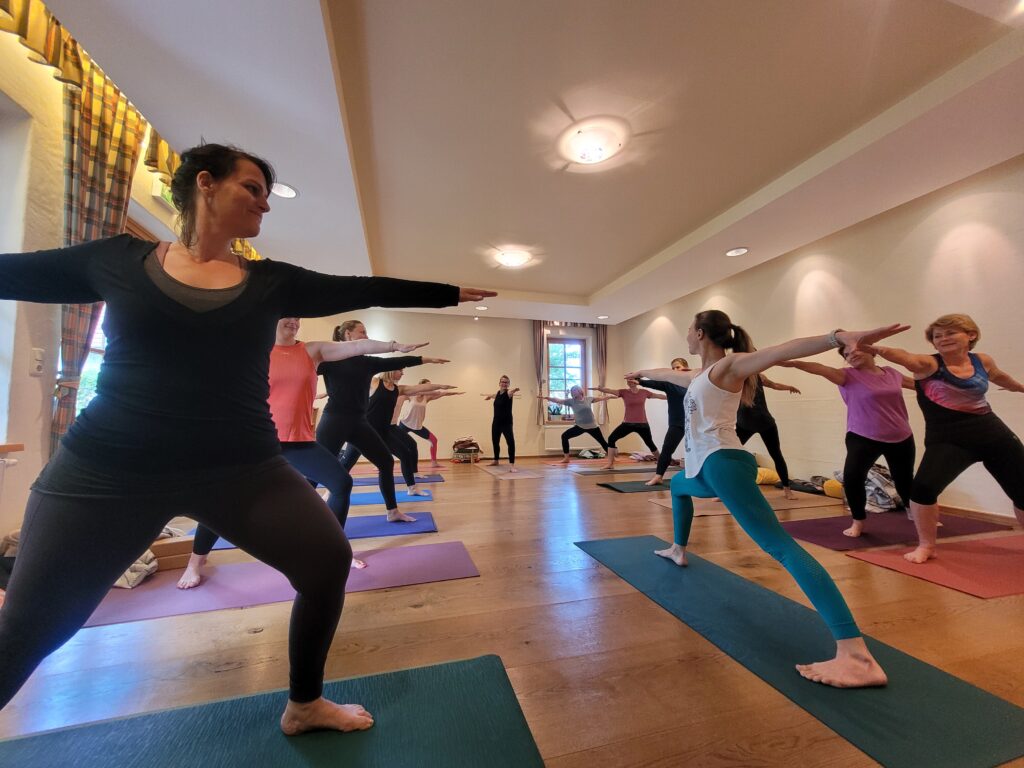 Yoga Lehrerin und Schülerinnen üben im Süden Österreichs den Krieger zwei auf einer Fasten Woche