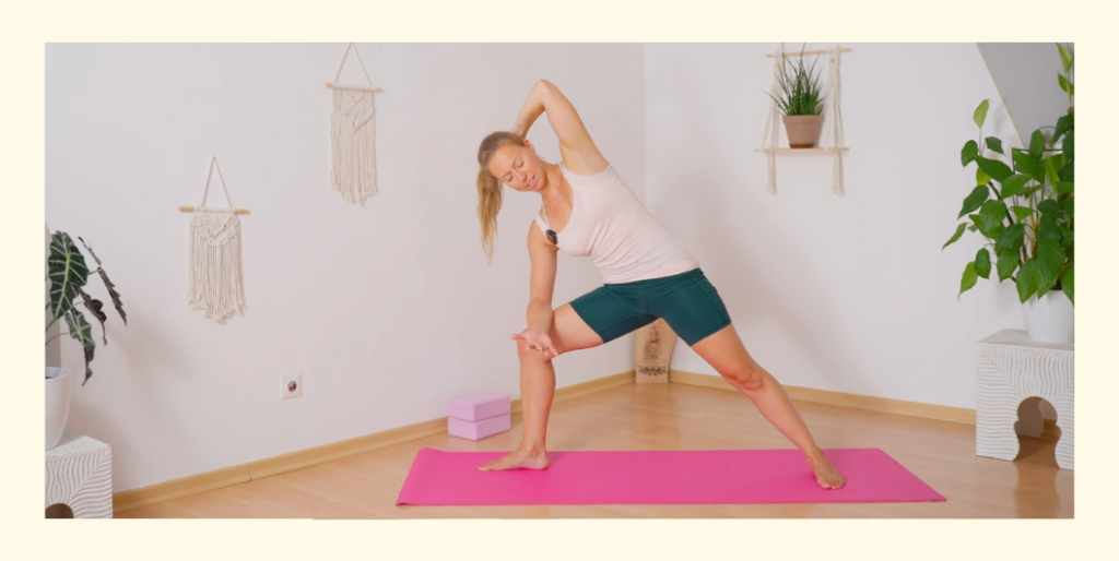 Frau zeigt Hatha Yoga Übungs Variante vom Seitlichen Winkel mit einer Hand am Hinterkopf