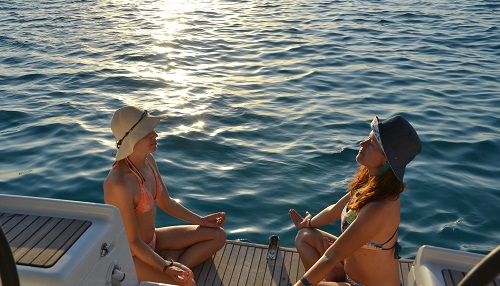 Zwei Frauen meditieren beim Yoga Retreat am Segelboot