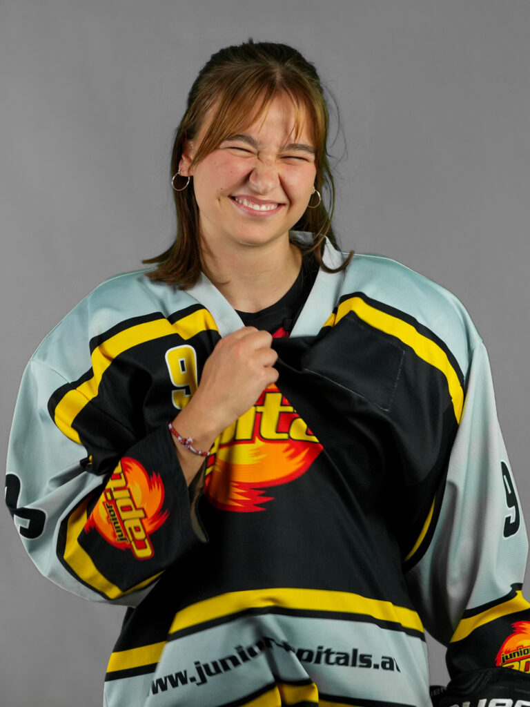 Portrait einer lachenden Frau in Eishockey Montur