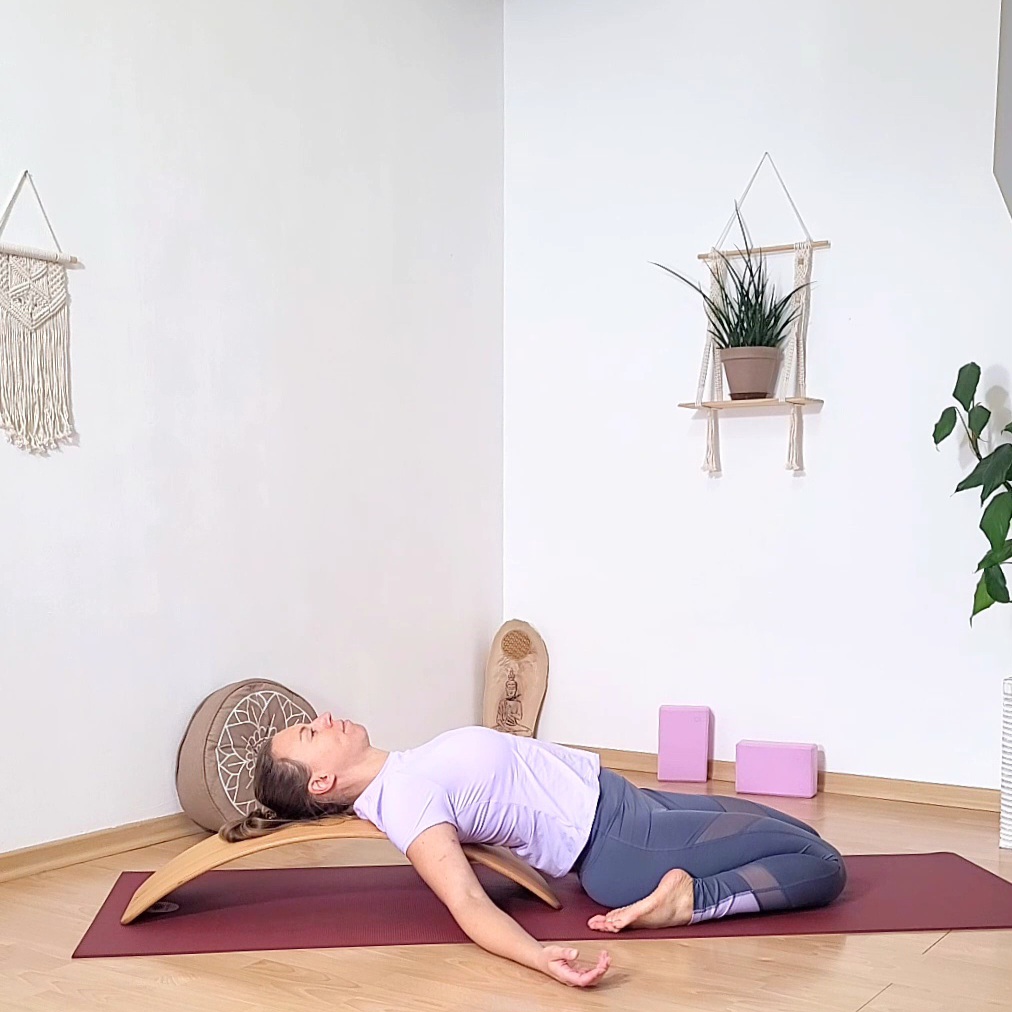 Yoga Lehrerin sitzt zwischen ihren Fersen, den Oberkörper auf das.Brett abgelegt