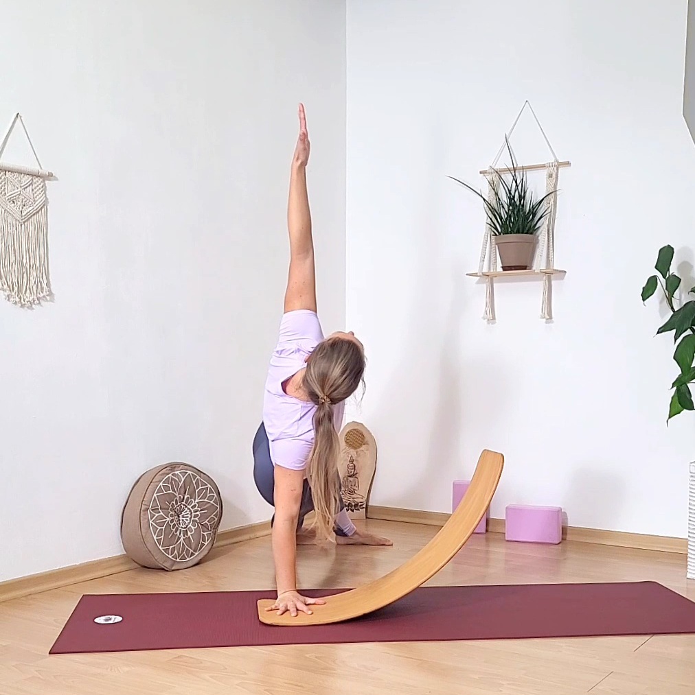 Yogaschülerin in der Seitlichen Brett Haltung mit einer Hand nahe der Kante des Yogabretts