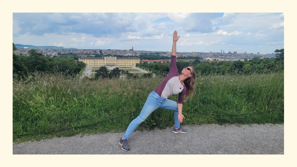 Sabrina im seitlichen Winkel mit Wiese, Schloss Schönbrunn und Skyline als Hintergrund als Titelbild für die besten Yoga Studios in Wien