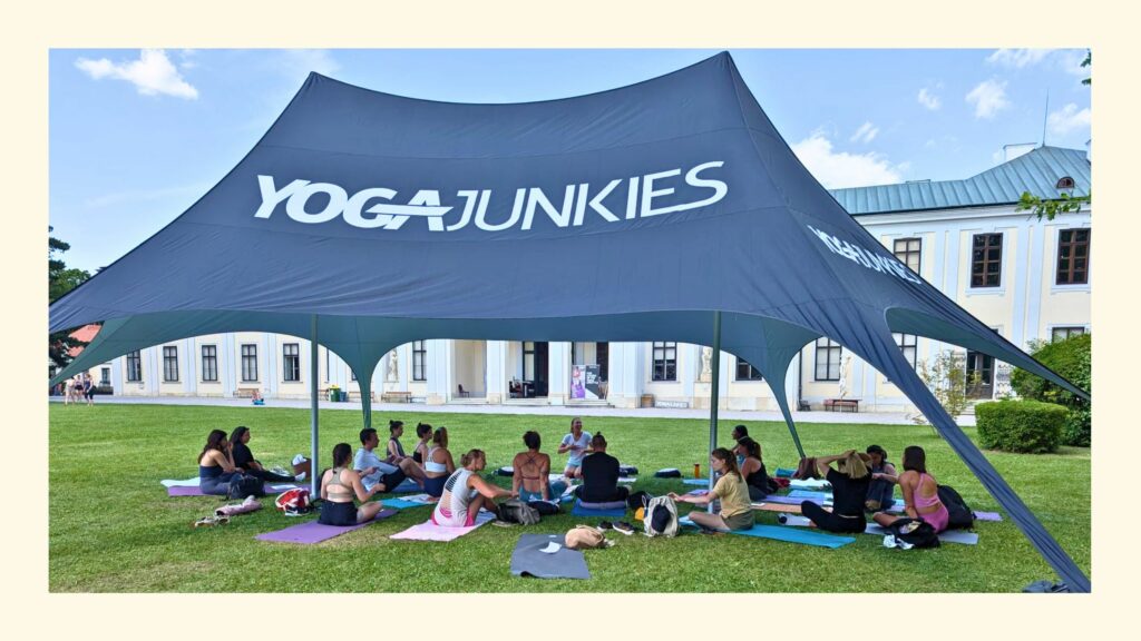 Yoga Junkies Zelt auf der Wiese mit Lehrerin Sabrina und Teilnehmenden vorm Schloss Hetzendorf beim Festival 2025 in Wien