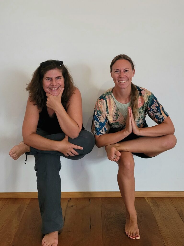 Yogalehrerin Sabrina Farkas und Mentaltrainerin Christina Schriefl lächelnd in einbeiniger Pose beim Yoga & Mentaltraining Retreat
