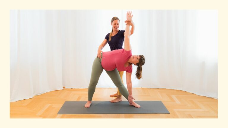 Schwangere übt das Yoga Dreieck mit Unterstützung ihrer Lehrerin Sabrina im Yogastudio in Wien