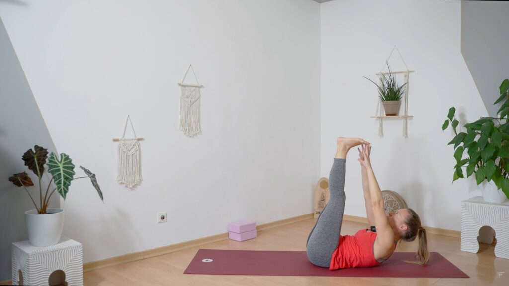 Yogalehrerin Sabrina zeigt eine Yoga Übung zur Kräftigung der Bauch Muskulatur in Rückenlage