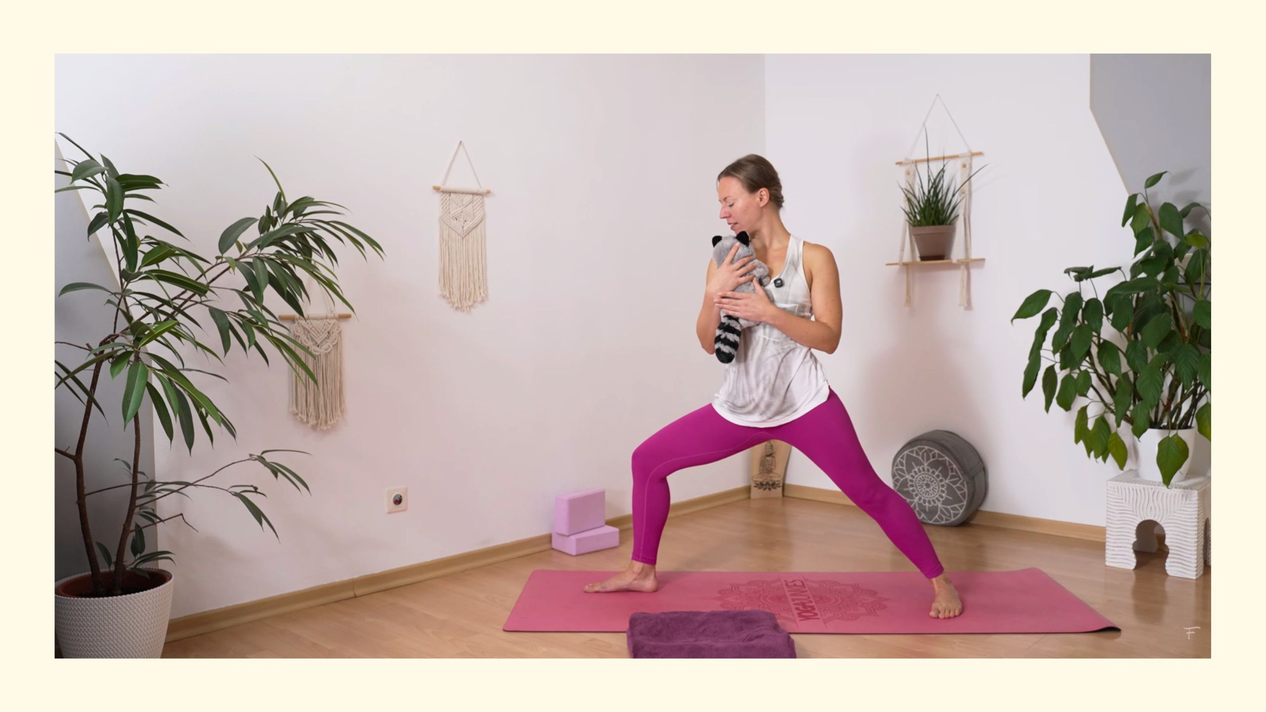 Yogalehrerin Sabrina aus Wien beim online Mama Baby Yoga in Krieger 2 Position mit Stofftier statt Kind am Arm
