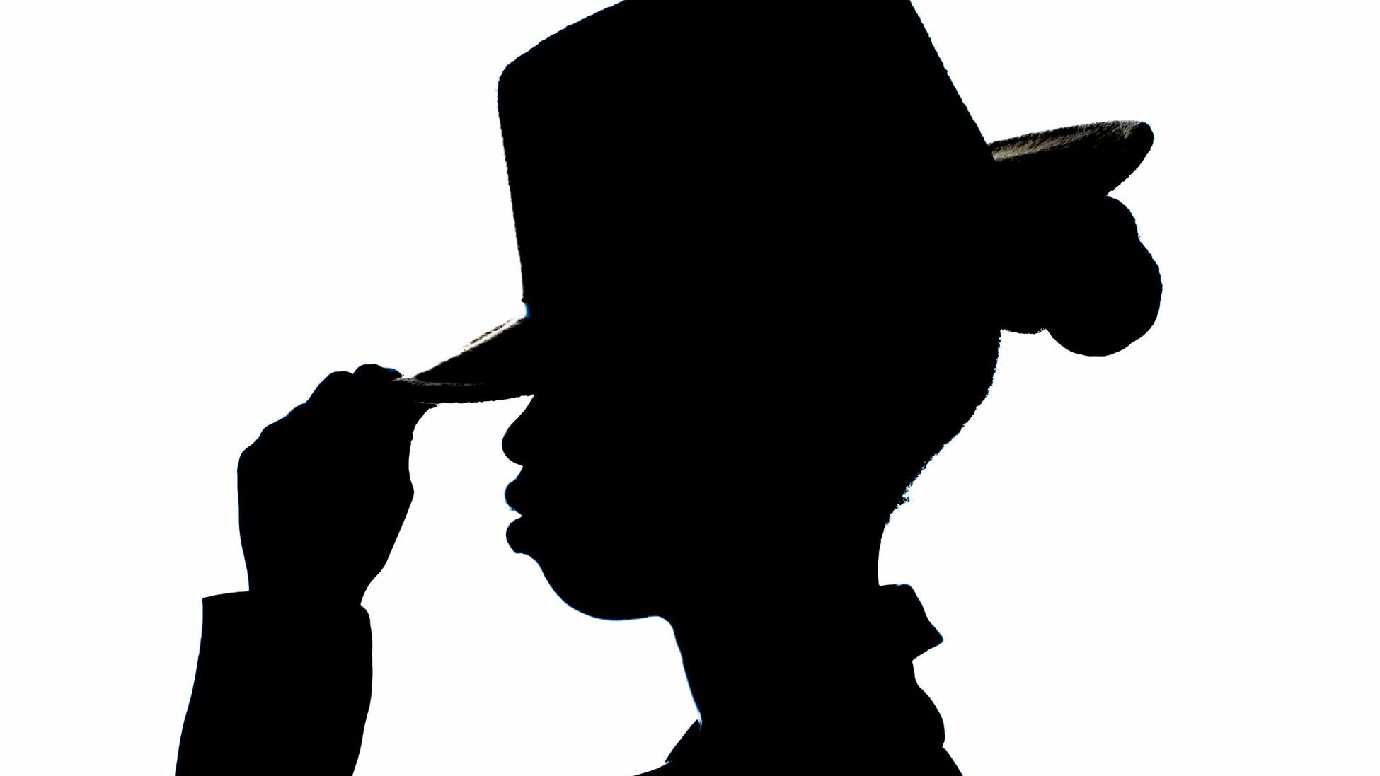 Elegant black silhouette of a person tipping a hat on white background.